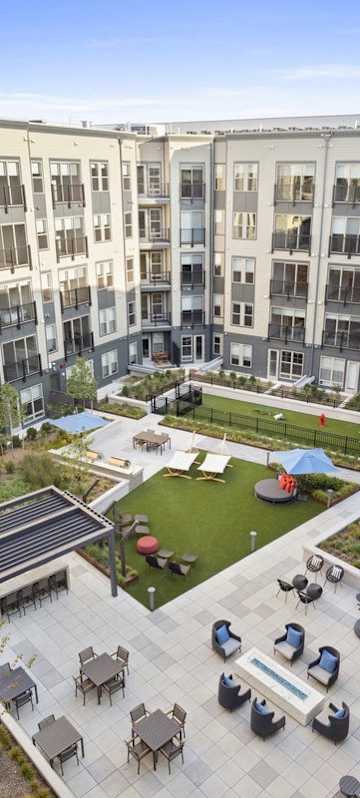 A courtyard with a fountain and seating area surrounded by apartment buildings.