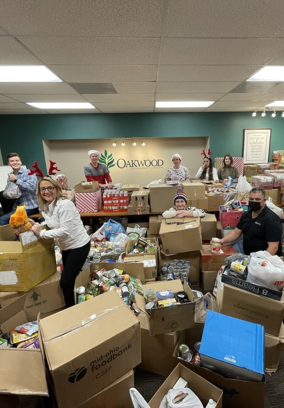 a group of people standing in a room filled with boxes of donations