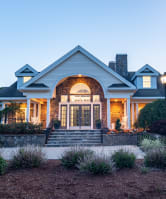 the front of a house with a porch at dusk