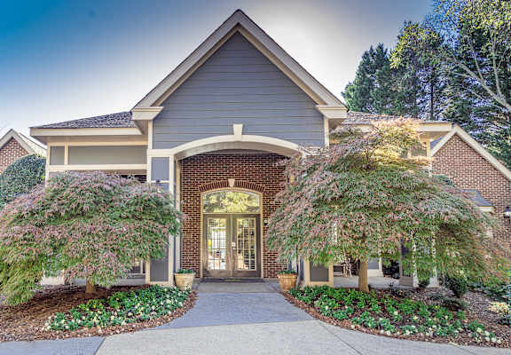 the front of a house with a walkway and two trees at Radbourne Lake Apartments, Charlotte