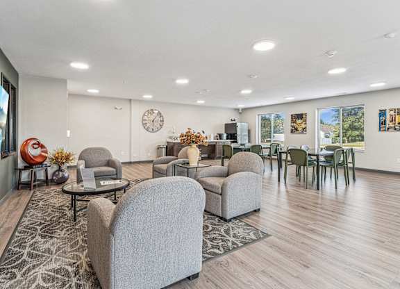 A living room with a grey sofa and a wooden floor.