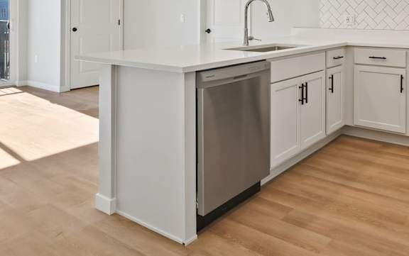 A modern kitchen with stainless steel appliances and white cabinets at Lochner Apartments, Minnesota, 55110