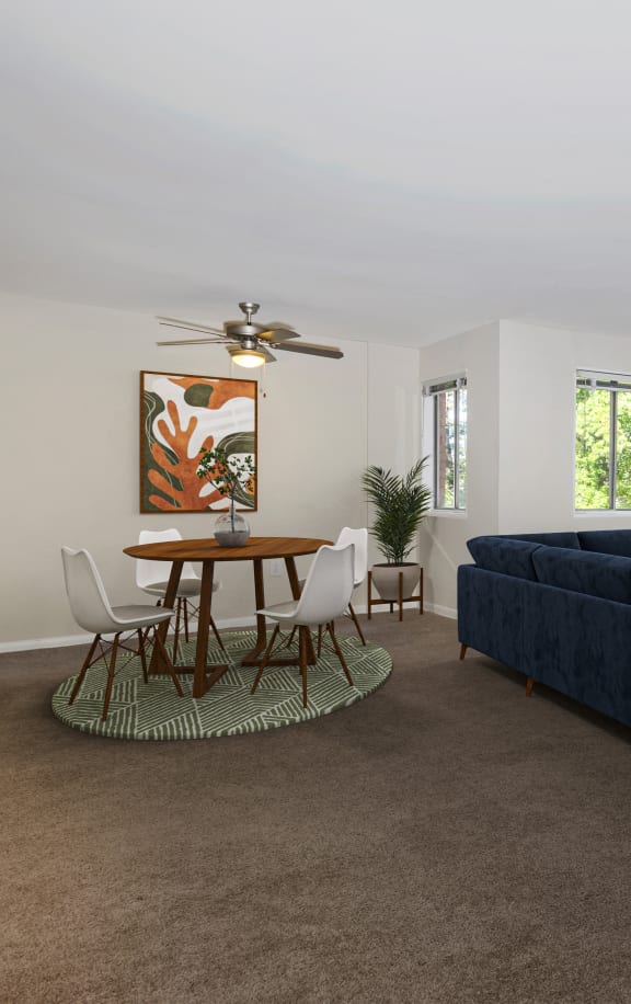 a living room with a blue couch and a table and chairs