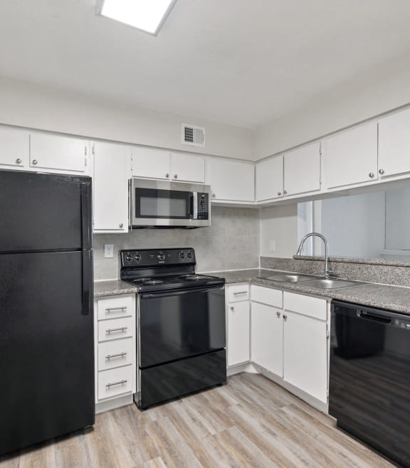 a kitchen with black appliances and white cabinets