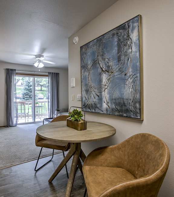 A living room with a brown chair and a painting on the wall.