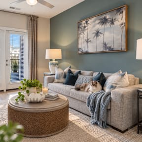 A living room with a couch, a coffee table, and a painting on the wall.