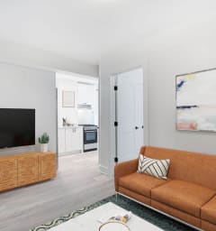 a living room with a couch and a table and a kitchen