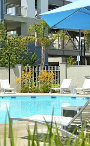 a swimming pool at a hotel with chairs and an umbrella