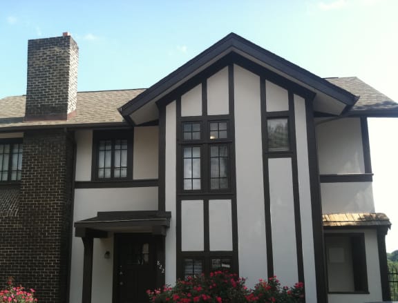 a black and white house with a car parked in front of it