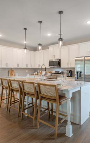 an open kitchen with a granite counter top and stools