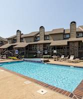 A swimming pool at Foxfire Apartments surrounded by fencing and landscaping.