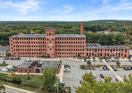 A large red brick building with a parking lot in front.