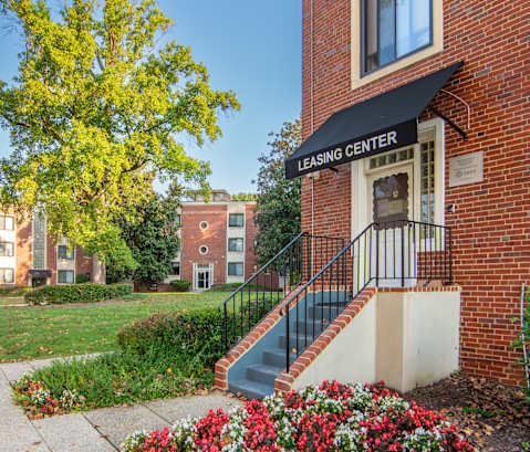 a brick building with stairs and flowers in front of it