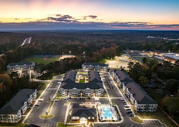 A large resort with a swimming pool and a parking lot.