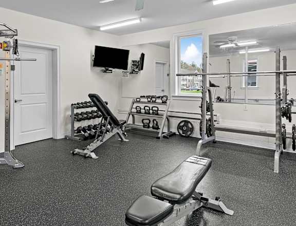 a home gym with weights machines and a tv