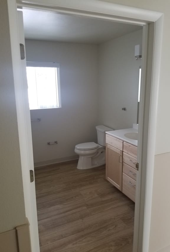 Image of toilet, towel and toilet paper racks, and sink