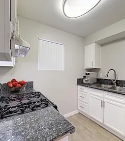 A well-lit, modern kitchen and living room with a dining area.