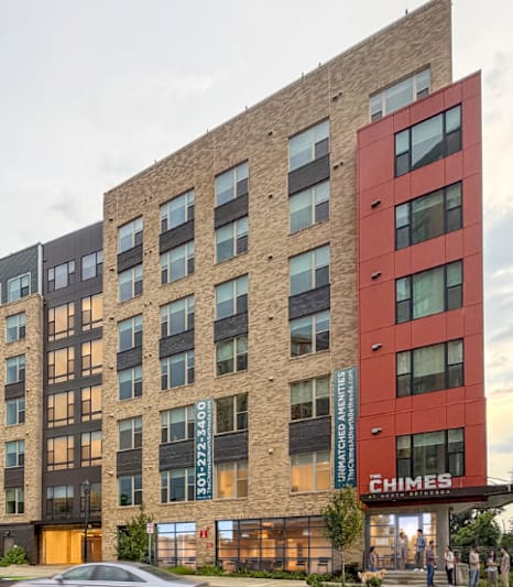 A modern building with a parking lot in front of it.