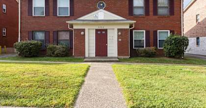 A red brick building with a white door and windows.