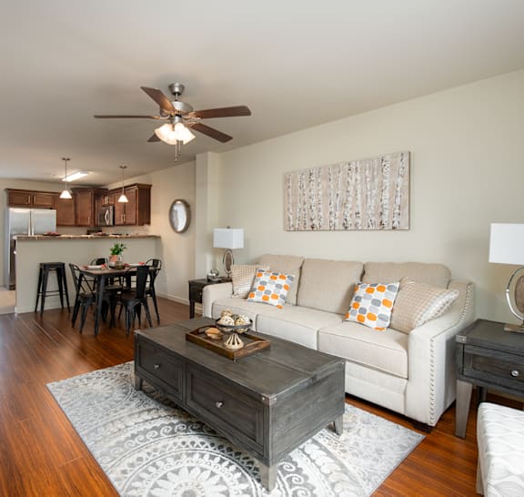 A living room with a white couch and a wooden coffee table.