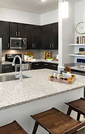 A kitchen with a granite countertop and a breakfast bar.