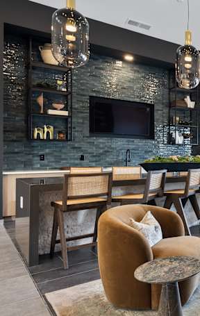 A living room with a brown couch, a coffee table, and a ceiling fan. at Montage West Lafayette Apartments, West Lafayette, IN, 47906