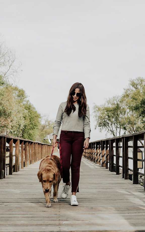 A woman walking a dog on a wooden bridge.at Copestone Apartments, Garden City Idaho
