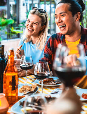 group of people sitting around a table drinking wine