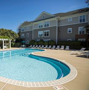 A large outdoor swimming pool with a pavilion and sun loungers.