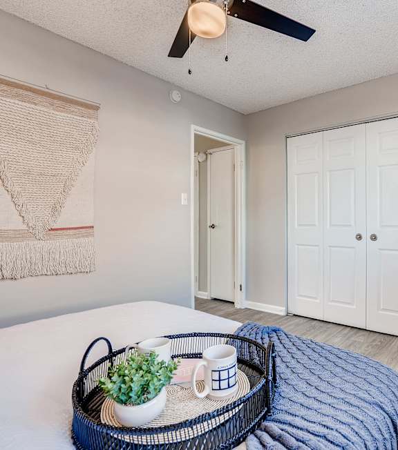 A living room with a white couch, blue chair, and a coffee table at Mountain Vista Apartments, Lakewood, CO, 80228