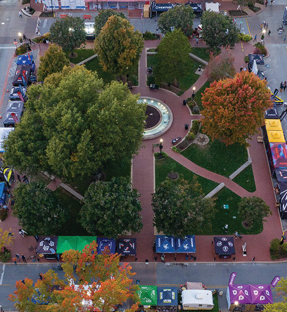 an aerial view of a city street with cars and trees
