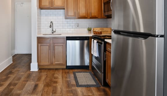 Galley kitchen with stainless steel appliances and wood cabinets at Fox Run Apartments, St. Charles, IL 60174