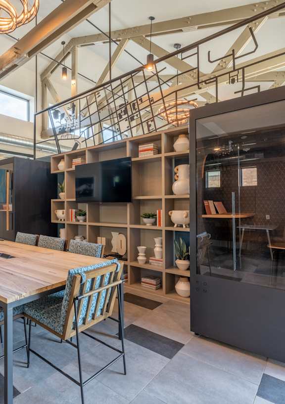a large table and chairs in a room with a bookshelf