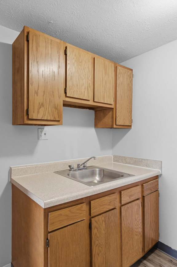 A kitchen with wooden cabinets and a white countertop.