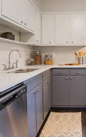 A modern kitchen with a stainless steel dishwasher and a black oven.
