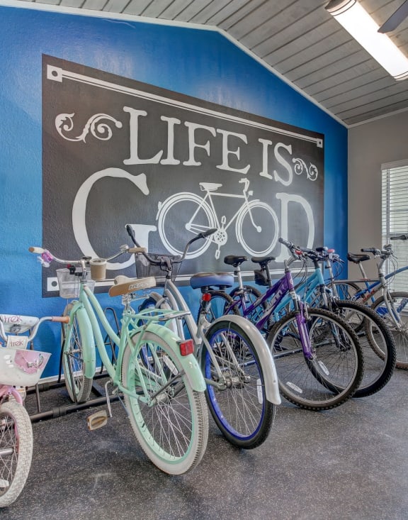 a group of bikes parked in front of a wall with a sign that says life is good