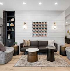 Modern lobby with seating area and reception desk at The Flats at West End Apartments, Minnesota, 55416