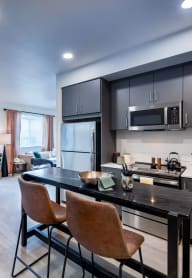 a living room with a dining room and a kitchen with a table and chairs