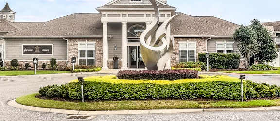 A large building with a circular driveway in front of it.