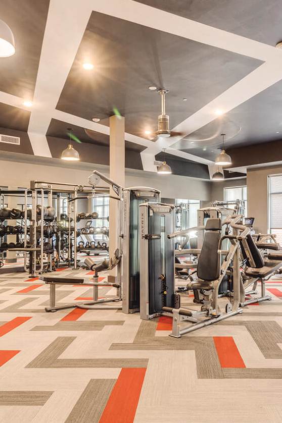 a workout room with treadmills and a tv