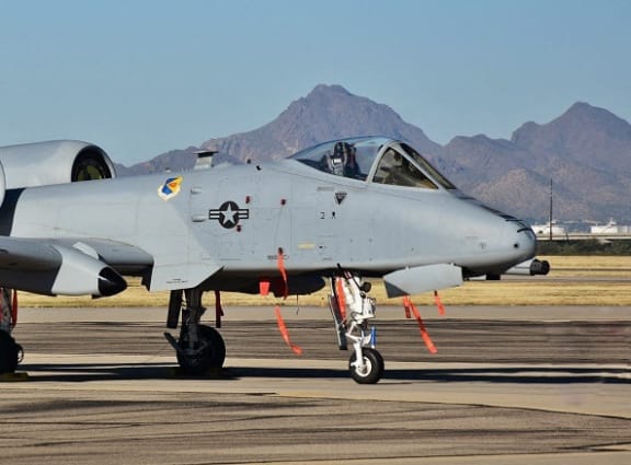 a fighter jet sitting on top of an airport runway