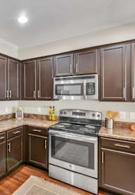 A kitchen with brown cabinets and stainless steel appliances.