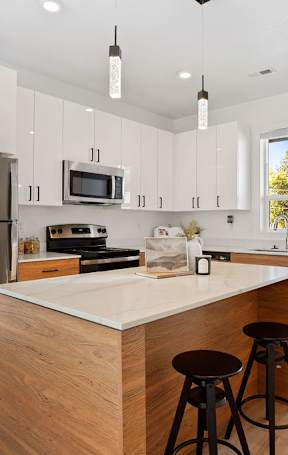 A modern kitchen with a wooden island and stainless steel appliances.