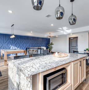 the reserve at the ballpark apartments clubhouse with kitchen island and dining room