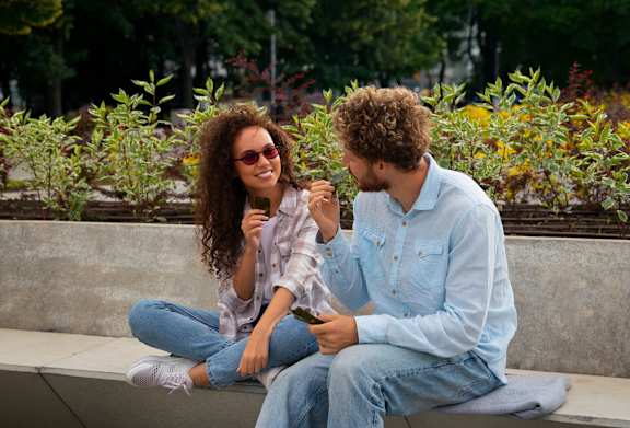 Two people sitting on a bench in a park at Alameda Apartments, Wembley, HA9 0HS
