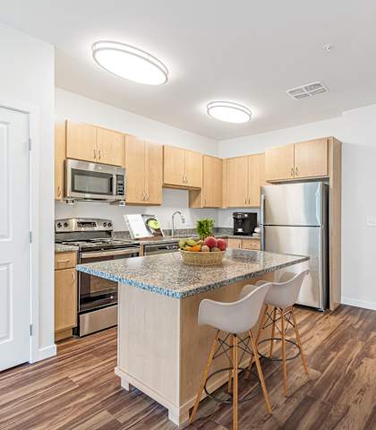 A kitchen with a table and chairs in the middle of it.