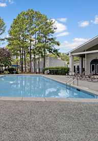 A large swimming pool with a building in the background.