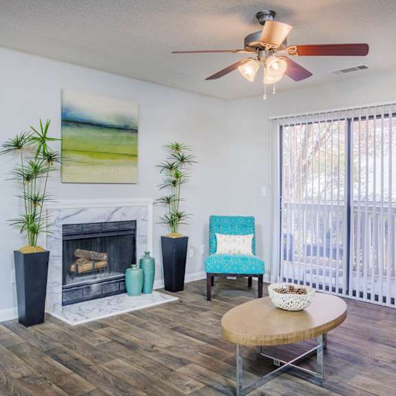 A spacious room with a fireplace, couches, and a ceiling fan.
