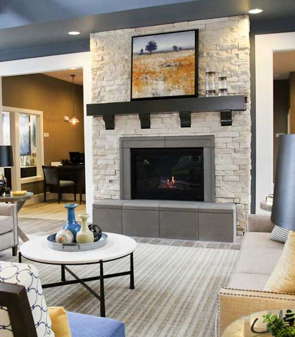 A living room with a fireplace and a painting above it.