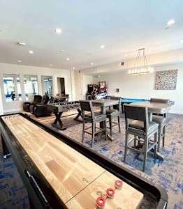 A billiard table in the middle of a room with a pool table in the background.